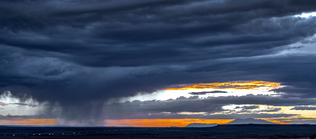 A panoramic view of dark blue sunset cloudscape during thunderstorm in Arizona, USA