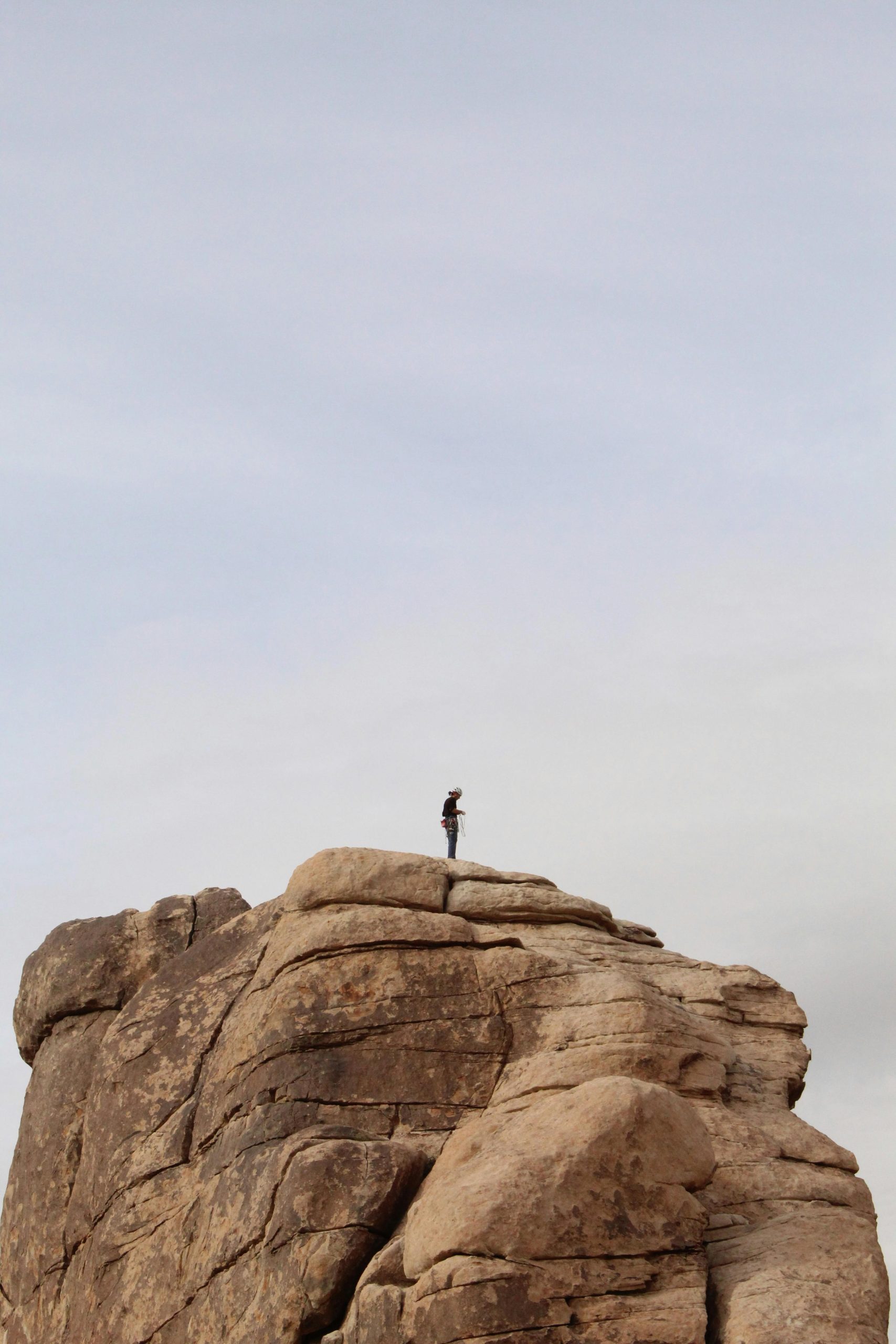 Person fixing rock climbing gear on mountain top