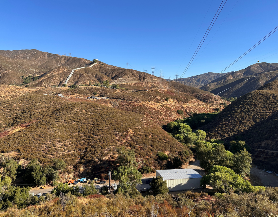 Steel transmission structures carrying power lines across a mountainous landscape